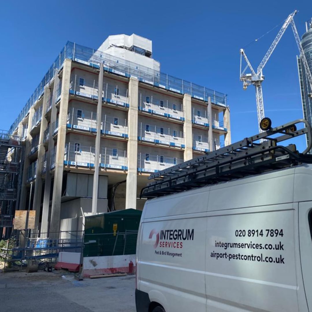 An Integrum Services branded van near a crane and town block